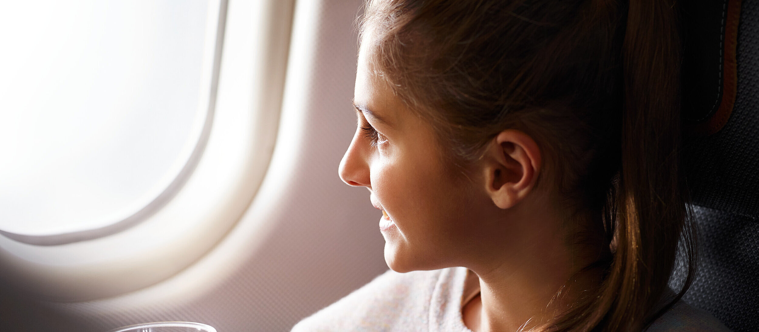 A child sits on a plane and looks outside