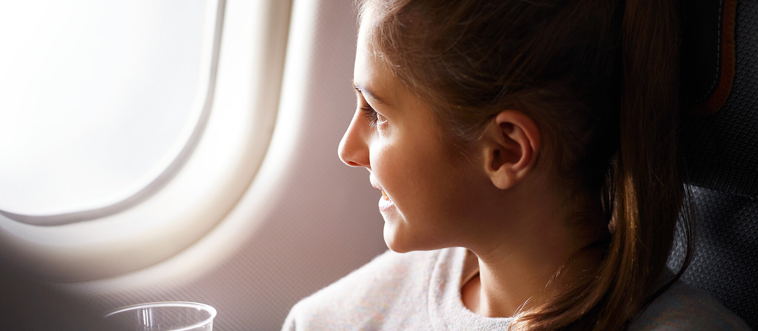 Ein Kind sitzt im Flugzeug und schaut nach draußen